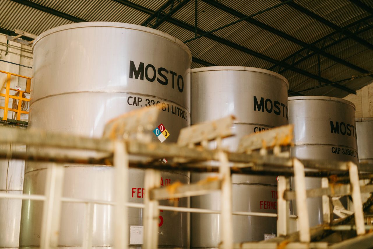 Services Interior view of an industrial tequila distillery with large metal containers labeled 'Mosto'.