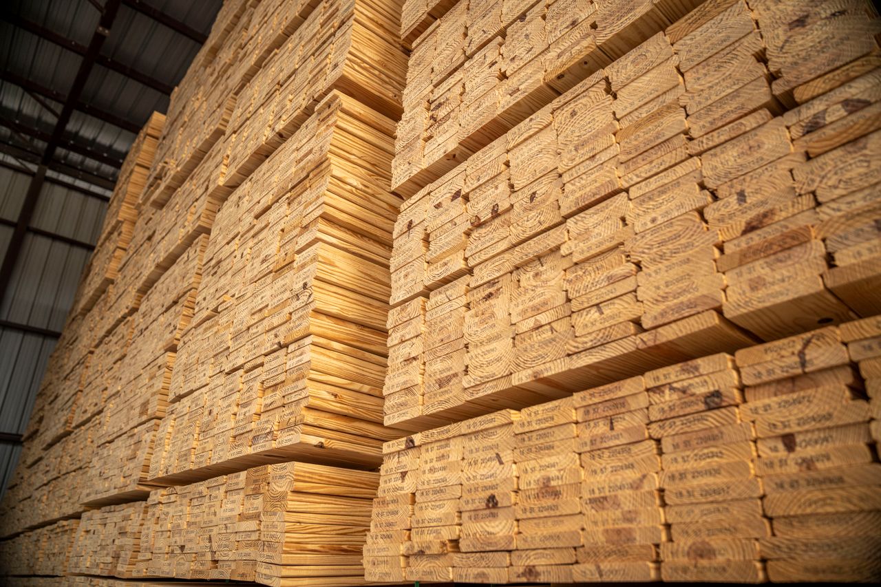 Crafting Captivating Headlines: Your awesome post title goes here Large stacks of lumber stored in an industrial warehouse, showcasing woodworking materials.