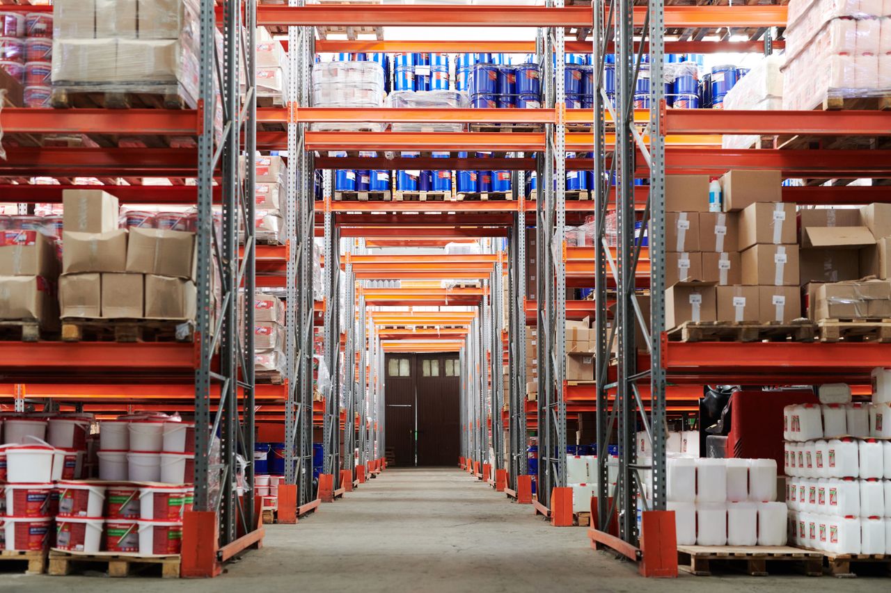 Services Wide angle view of a warehouse with stocked shelves and boxes.